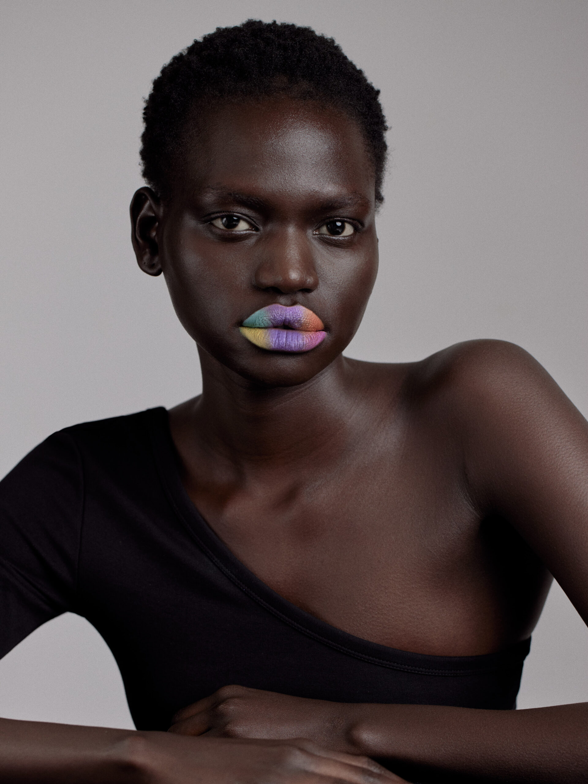 Black model sitting with brightly coloured lips